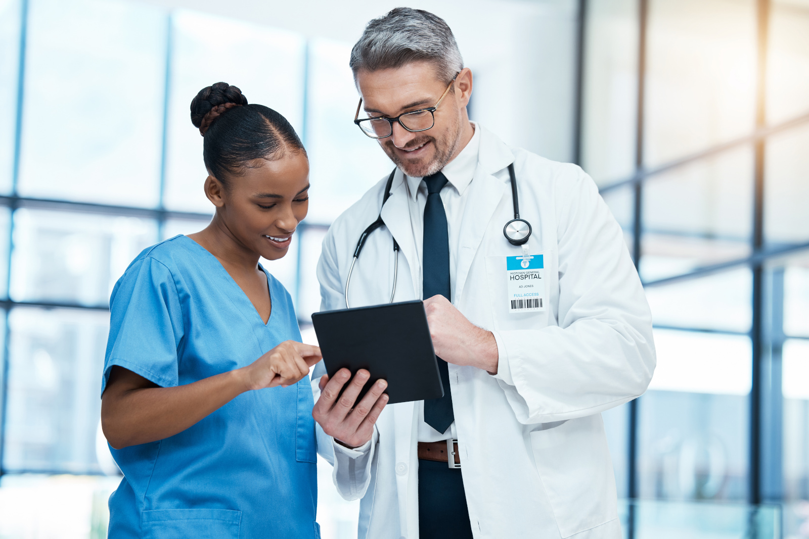 Teamwork, tablet and healthcare with a doctor and nurse working together as a team in the hospital. Collaboration, internet and medical with a man and woman surgeon at work on an online diagnosis