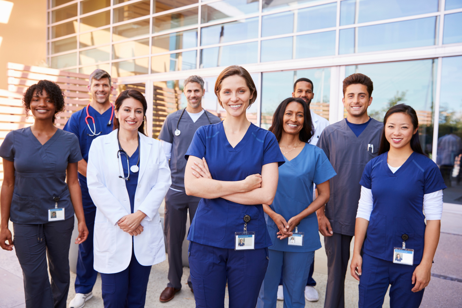 Team of healthcare workers with ID badges outside hospital Employee availability management with WorkTracker
