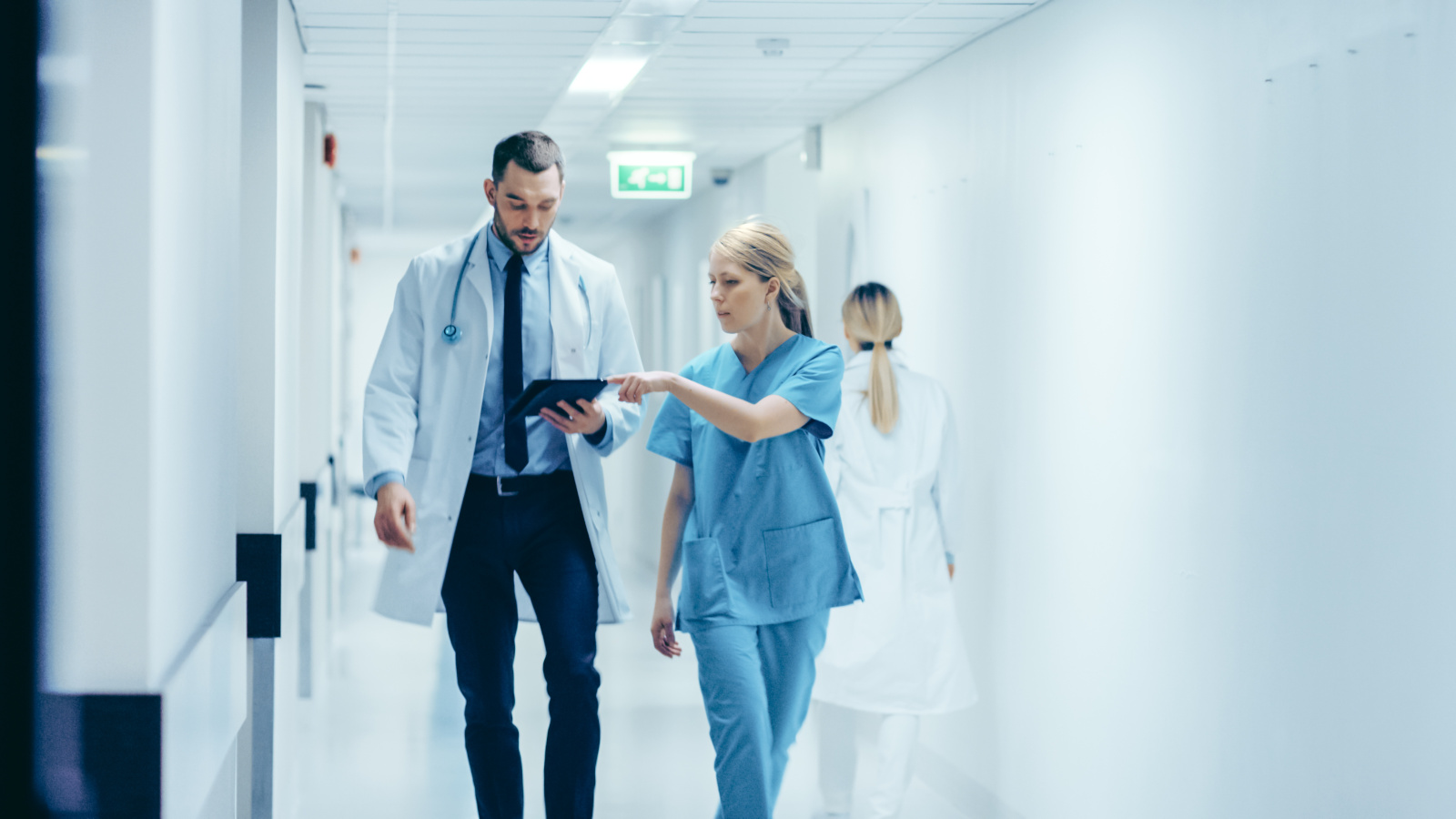 Nurse submitting timesheet to doctor in hospital corridor using the WorkTracker app