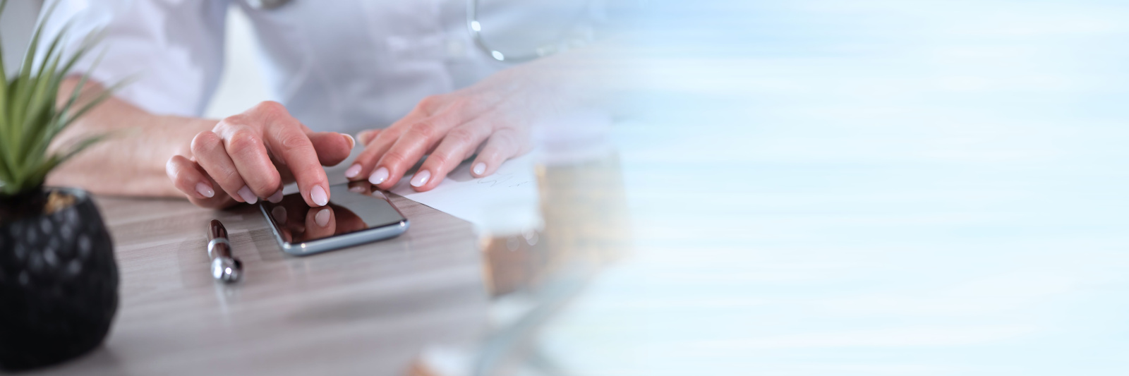 Female doctor using her mobile phone; panoramic banner