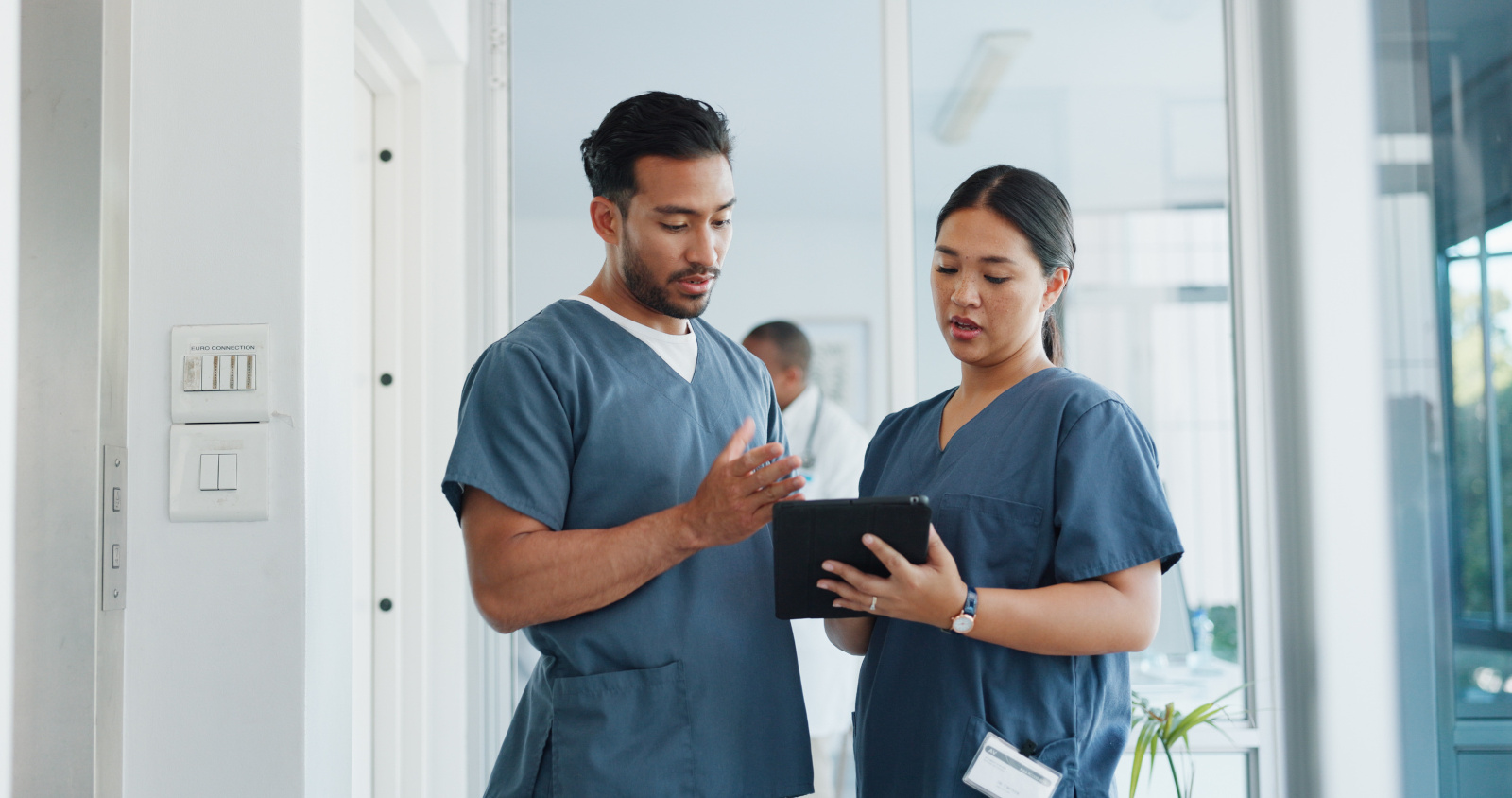 Nurse and Doctor in hospital corridor with WorkTracker app