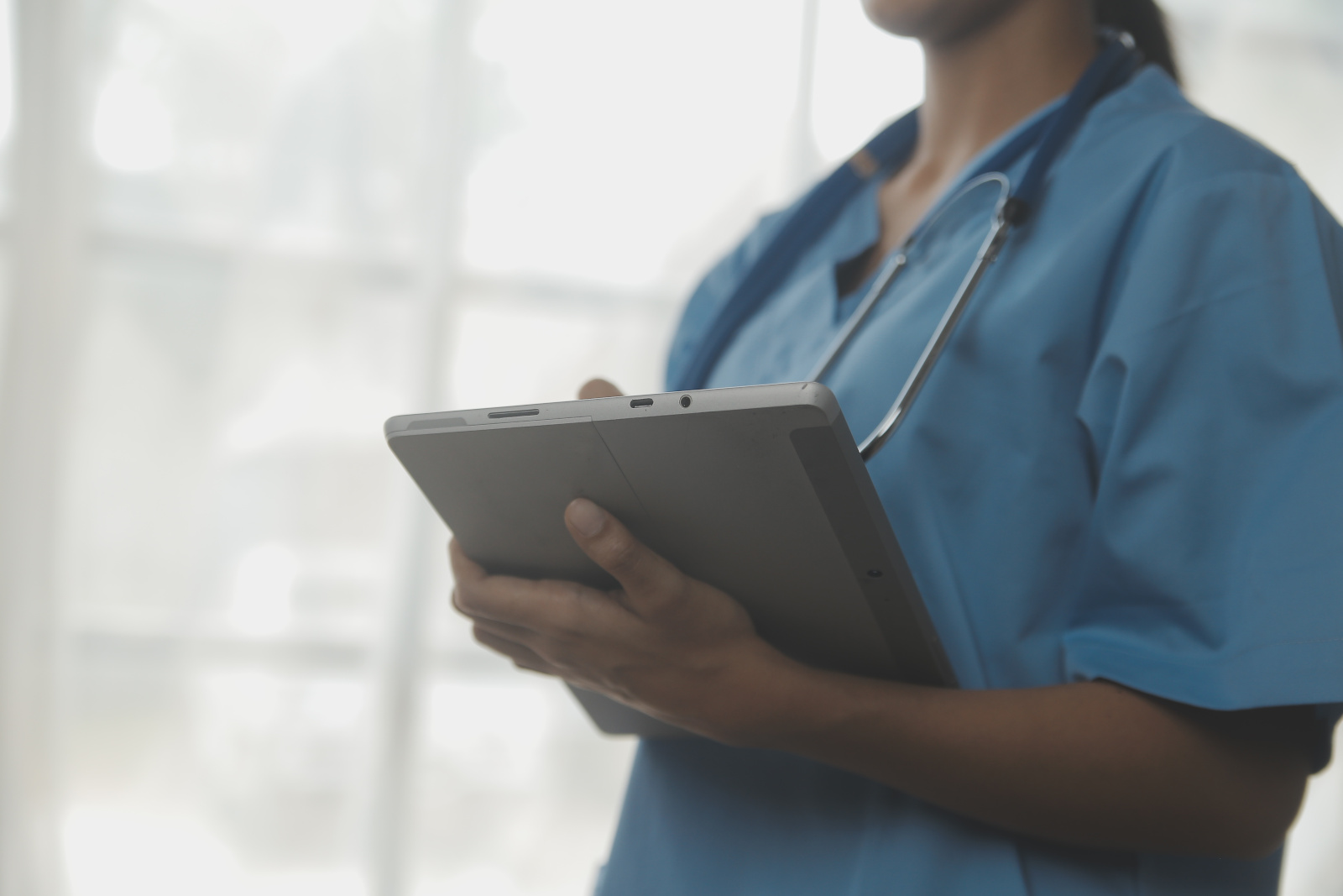 Beautiful young adult spanish female nurse or medical student at hospital WorkTracker branded mobile timesheet app
