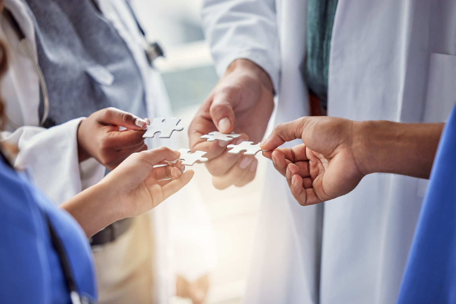 Puzzle, doctor hands or group of people teamwork, solution and healthcare goals, success or integration. Team building, game and clinic of nurse, medical men or women problem solving or collaboration Healthcare team working jigsaw concept for YouRecruit and WorkTracker