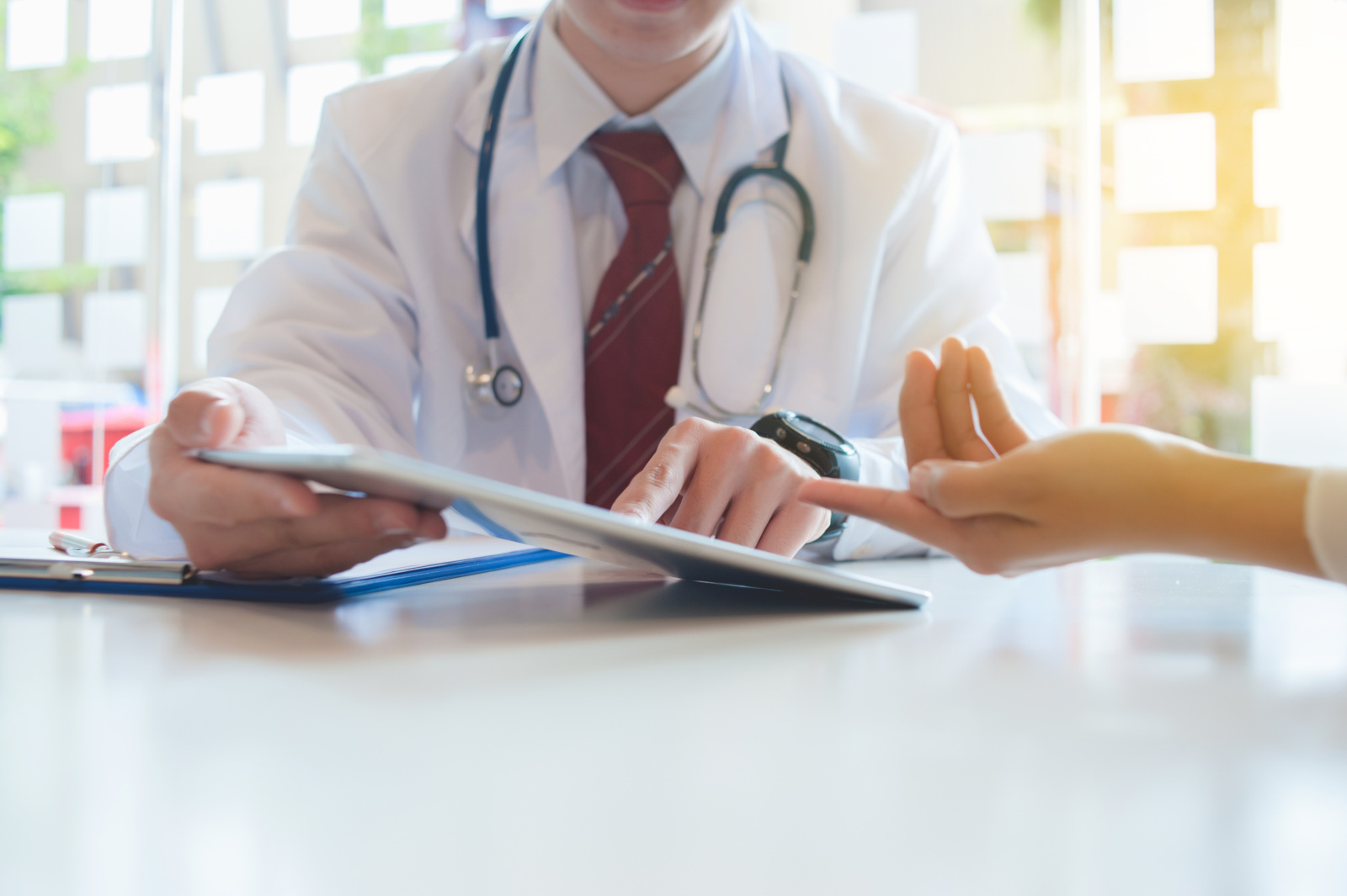 Doctor is consulting the patient with a digital tablet.healthcare and technology concept Doctor discussing WorkTracker mobile timesheet