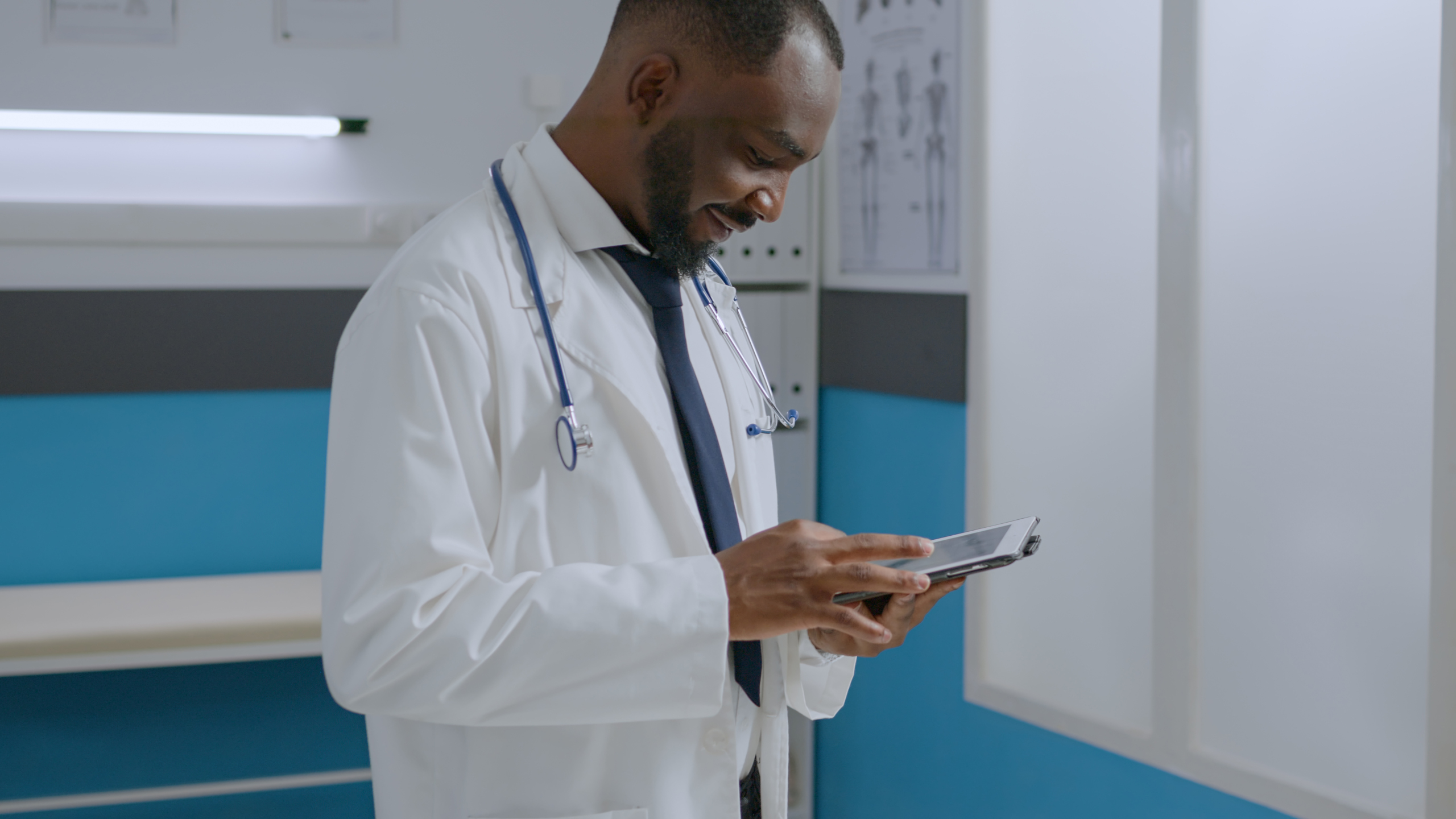 African doctor with tablet working within the YouRecruit staff communication platform: WorkTracker time recording software