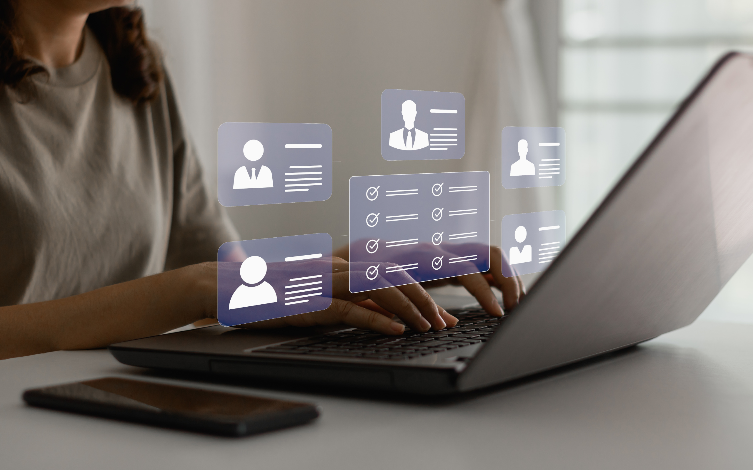 Recruitment agency consultant at desk with laptop using YouRecruit, there are workforce compliance icons overlaid