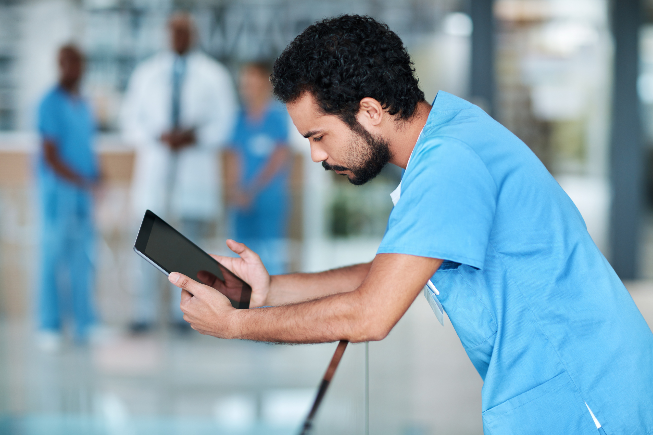 Healthcare worker with smart device, checking compliance notifications: The YouRecruit and WorkTracker staffing CRM software
