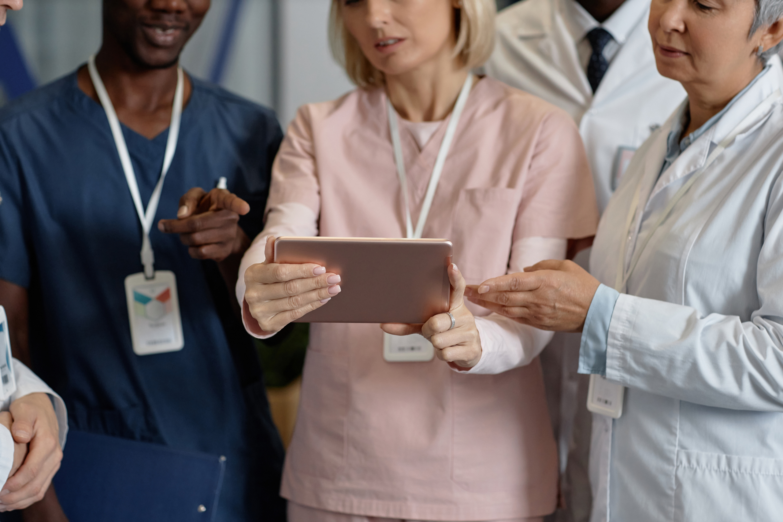 Temporary healthcare staff grouped around a tablet in hospital location and using the the WorkTracker shift management app
