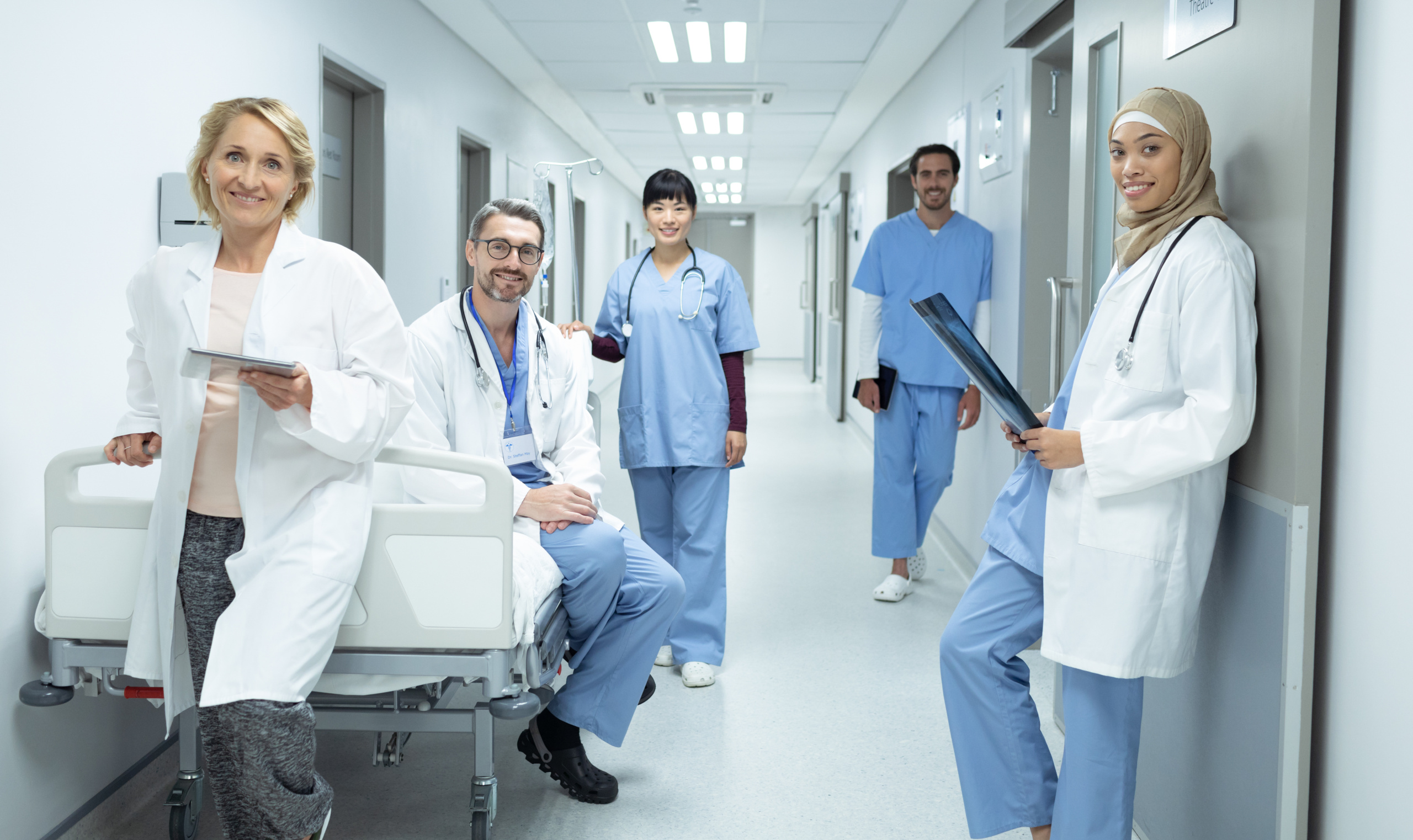 A group of happy healthcare staff on shift in hospital corridor: The YouRecruit healthcare staffing and compliance software