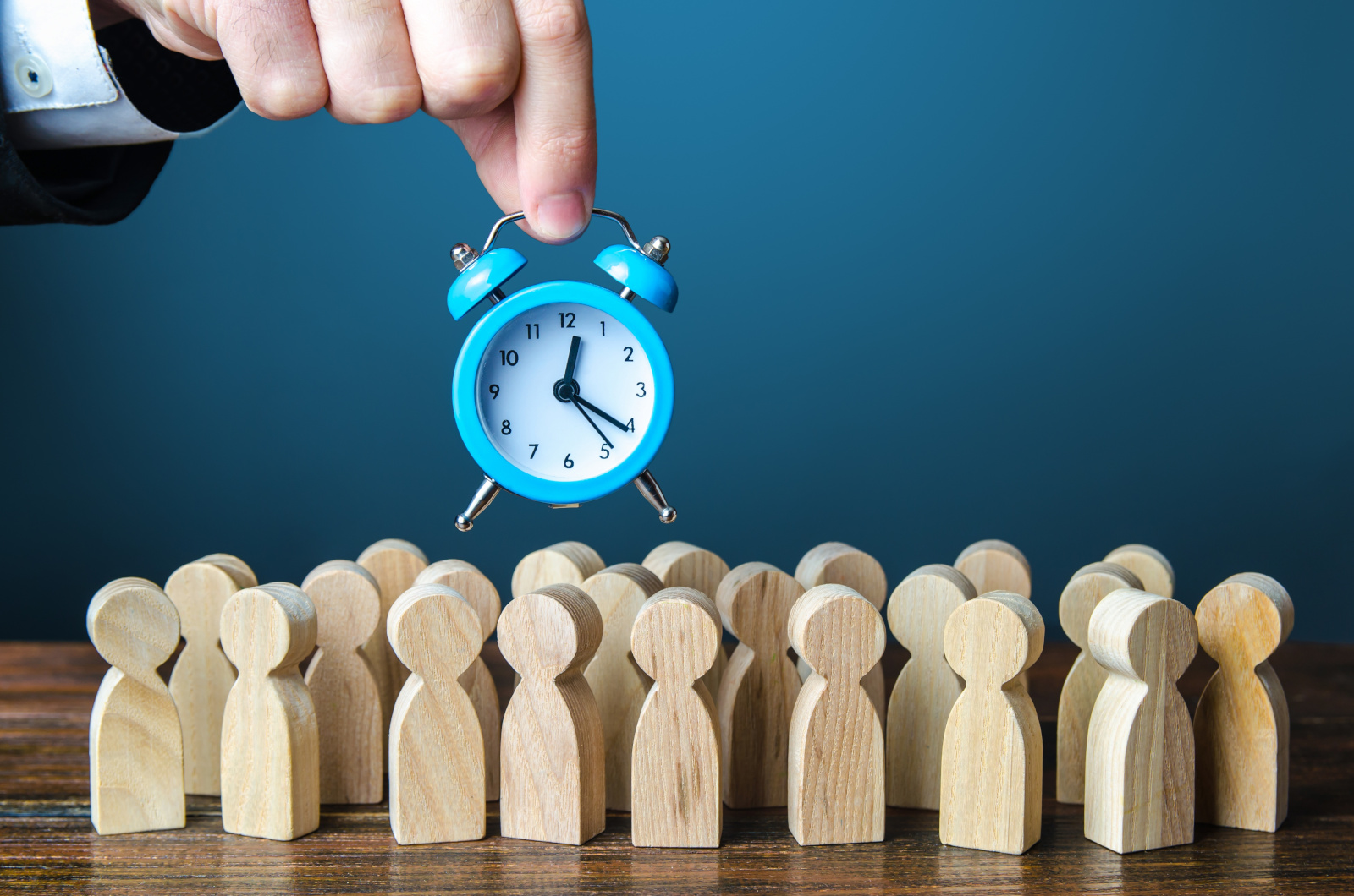 Concept image of an agency consultant holding an alarm clock over a group of people: YouRecruit recruitment agency software