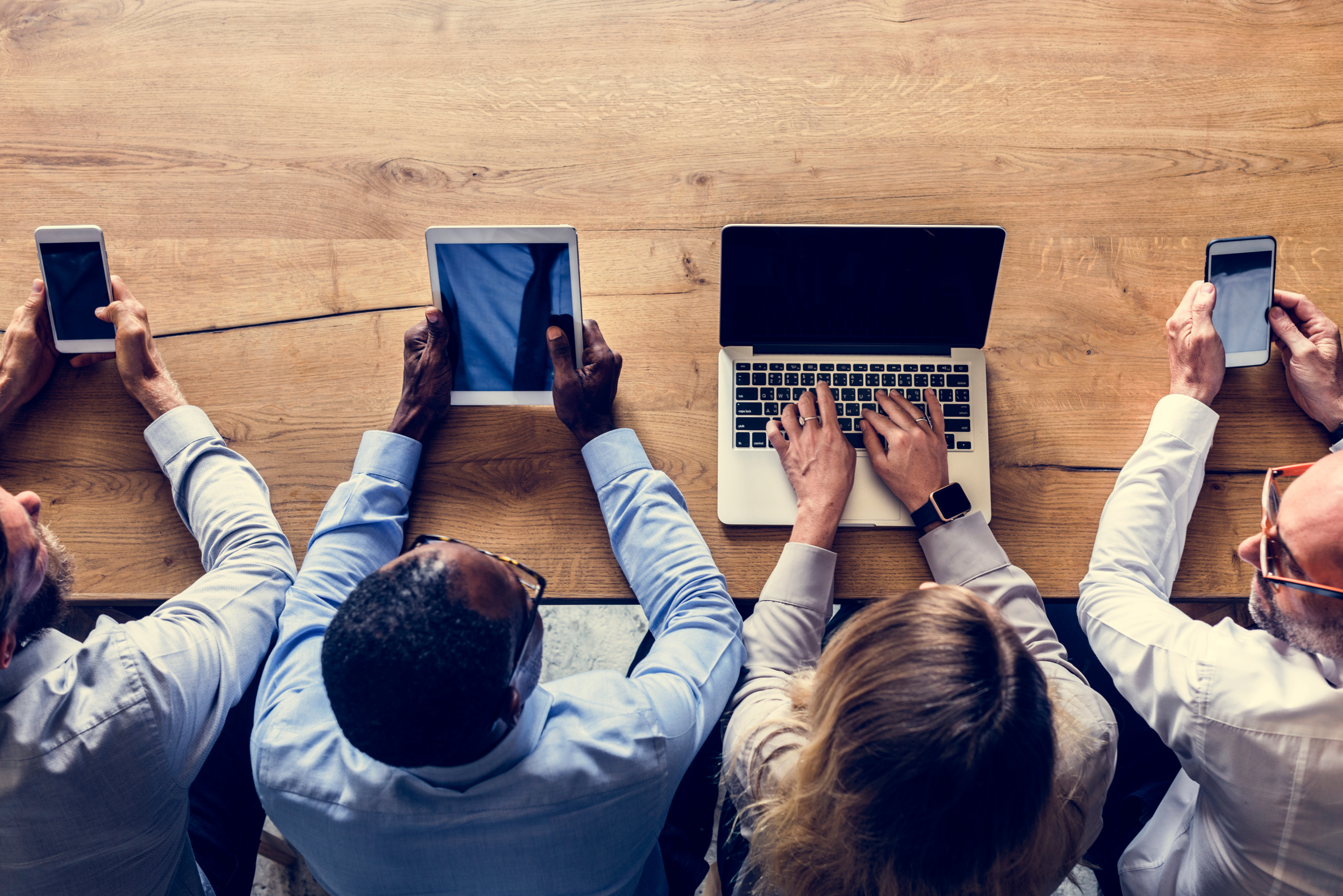 New employees with smart devices and agency consultant at laptop: Candidate onboarding with YouRecruit and WorkTracker