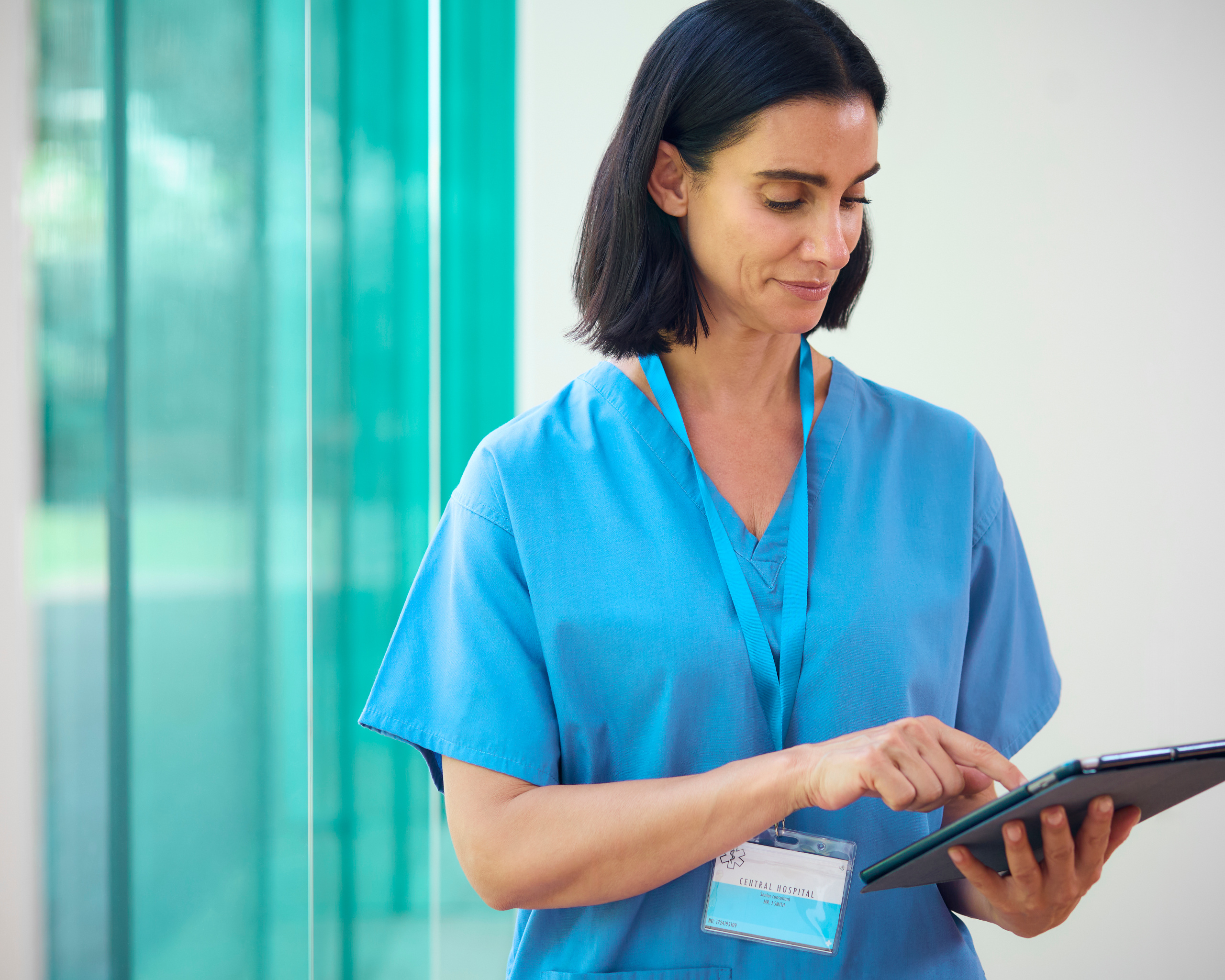 Temporary healthcare assistant at work with tablet: Using YouRecruit’s WorkTracker mobile workforce management app