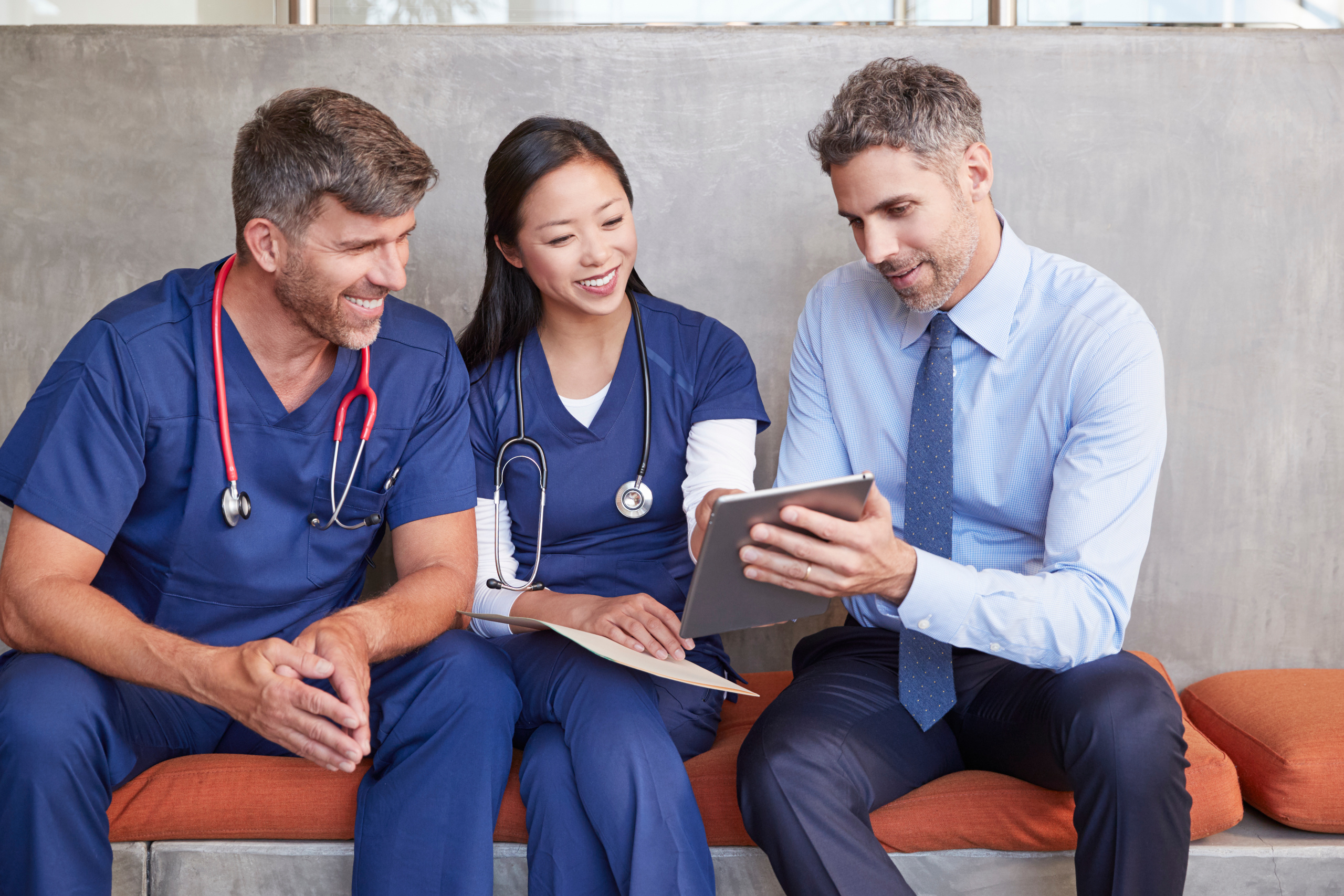  Two temporary healthcare employees along with hospital manager sharing a tablet: The YouRecruit staff communication platform