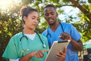 Female doctor and male nurse outdoors looking at tablet: Digital timesheets and the WorkTracker employee time tracking app