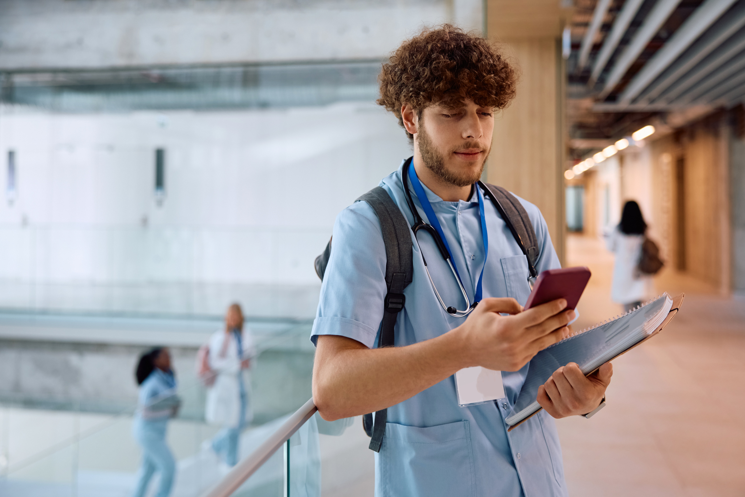 Healthcare worker in hospital holding smart device using the WorkTracker mobile workforce management app smart device