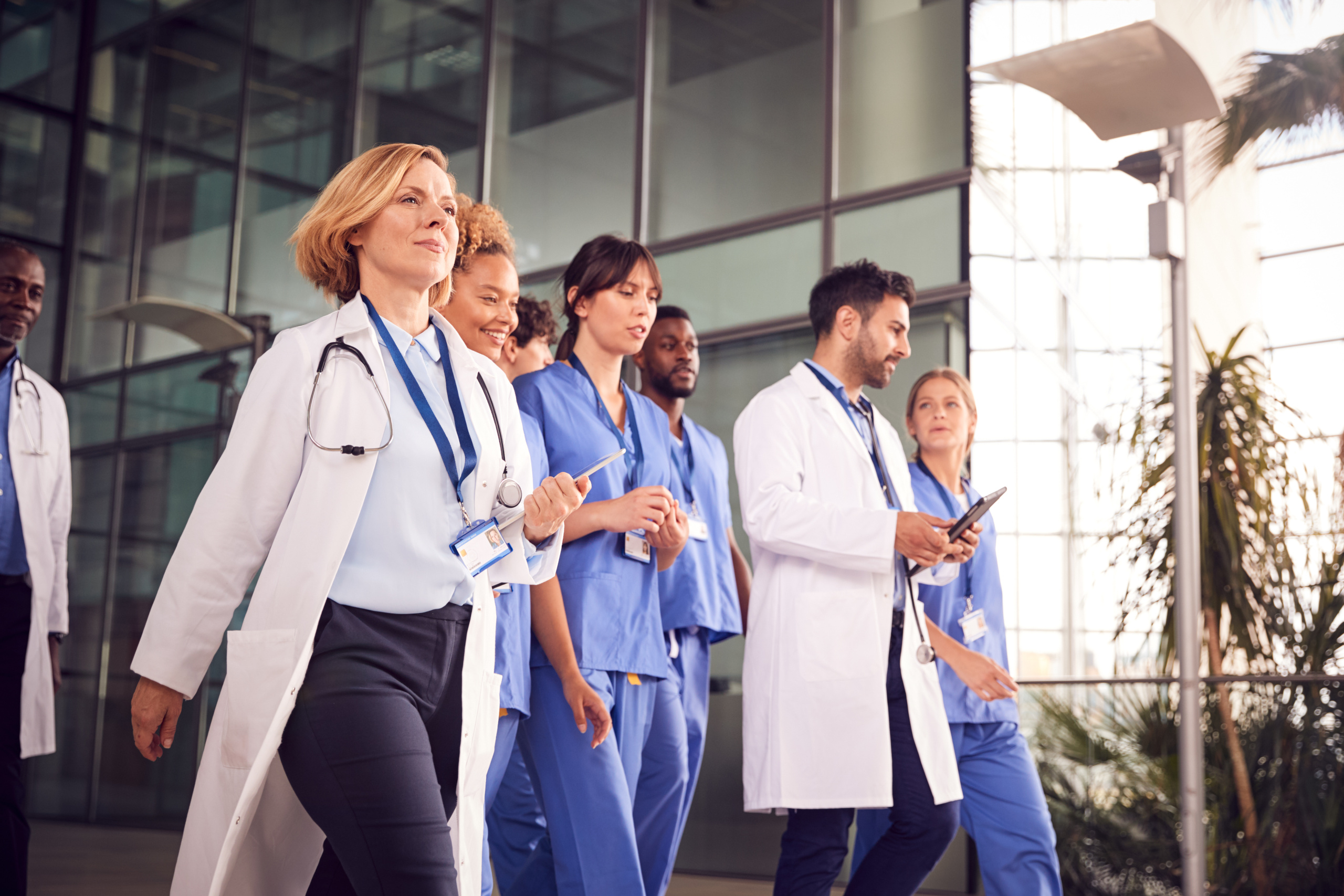 Medical team in different roles on the move in hospital, doctor holding tablet: The YouRecruit workforce management system