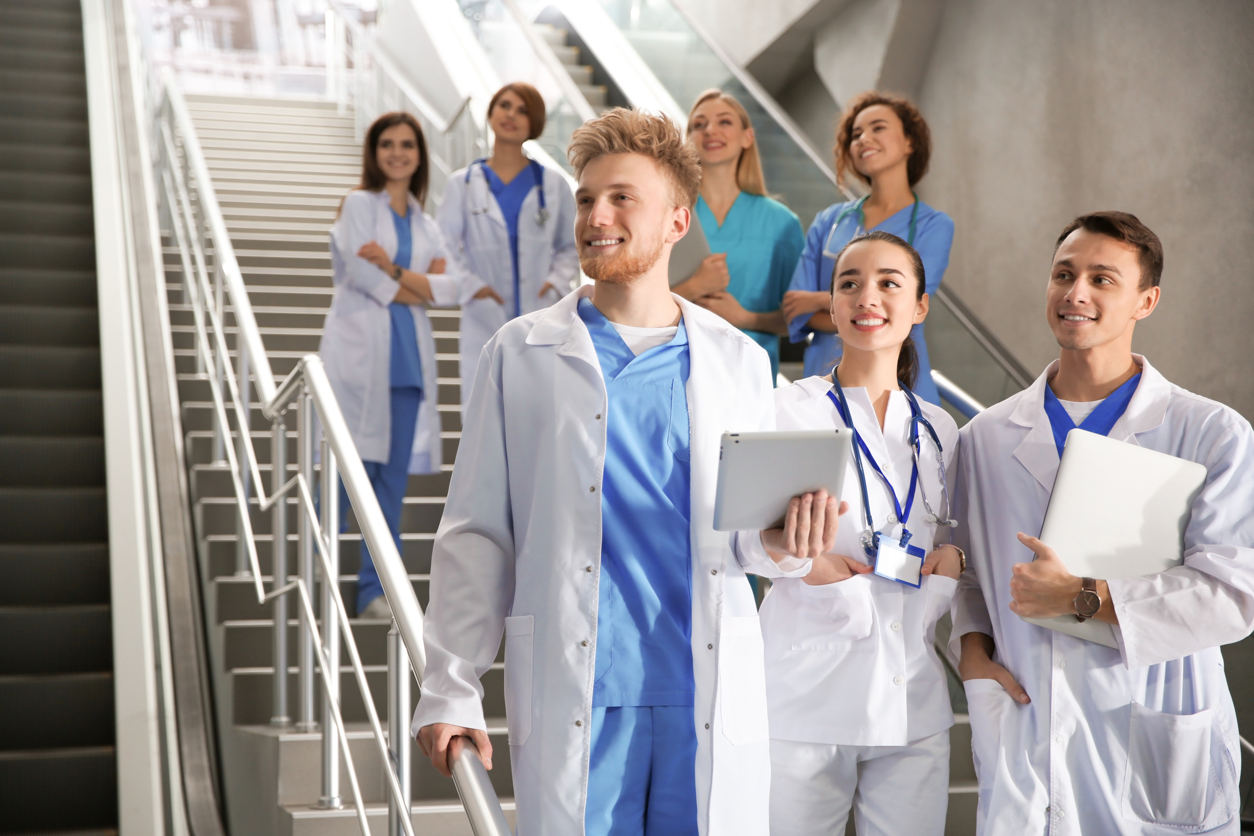 New healthcare employees on the stairwell of a hospital: Candidate onboarding with the YouRecruit staffing agency software