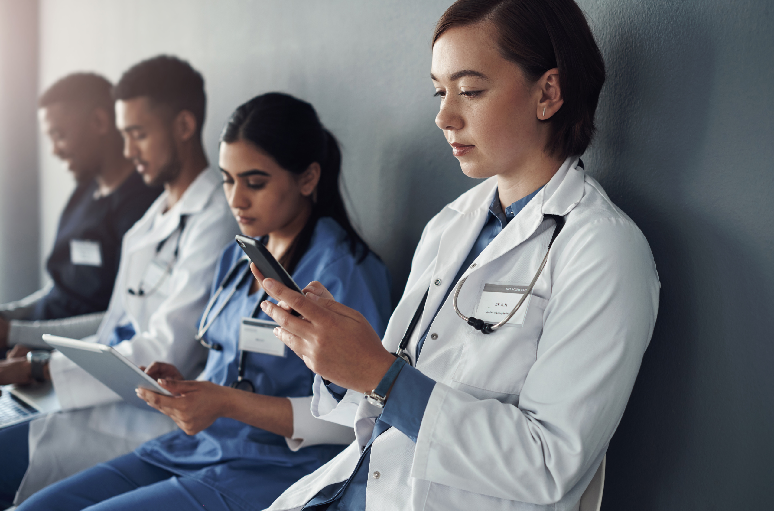 Healthcare staff in different roles, with smart devices: Staff availability with the YouRecruit workforce management system
