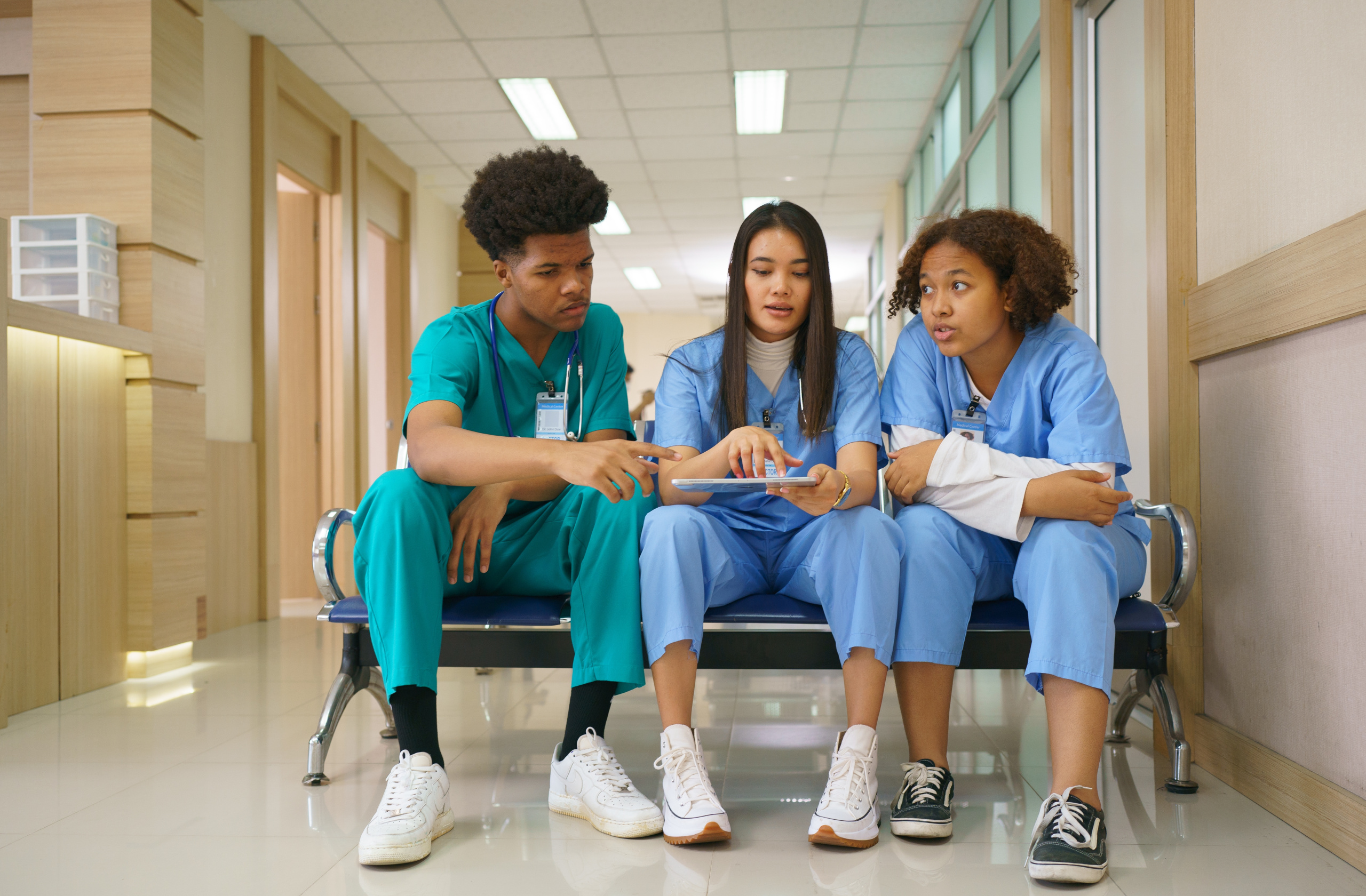 Three nurses relaxing in hospital, middle nurse holding a tablet: The YouRecruit recruitment agency timesheet software