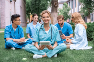 Group of happy healthcare staff during break with foremost female holding tablet: The YouRecruit Workforce Management System