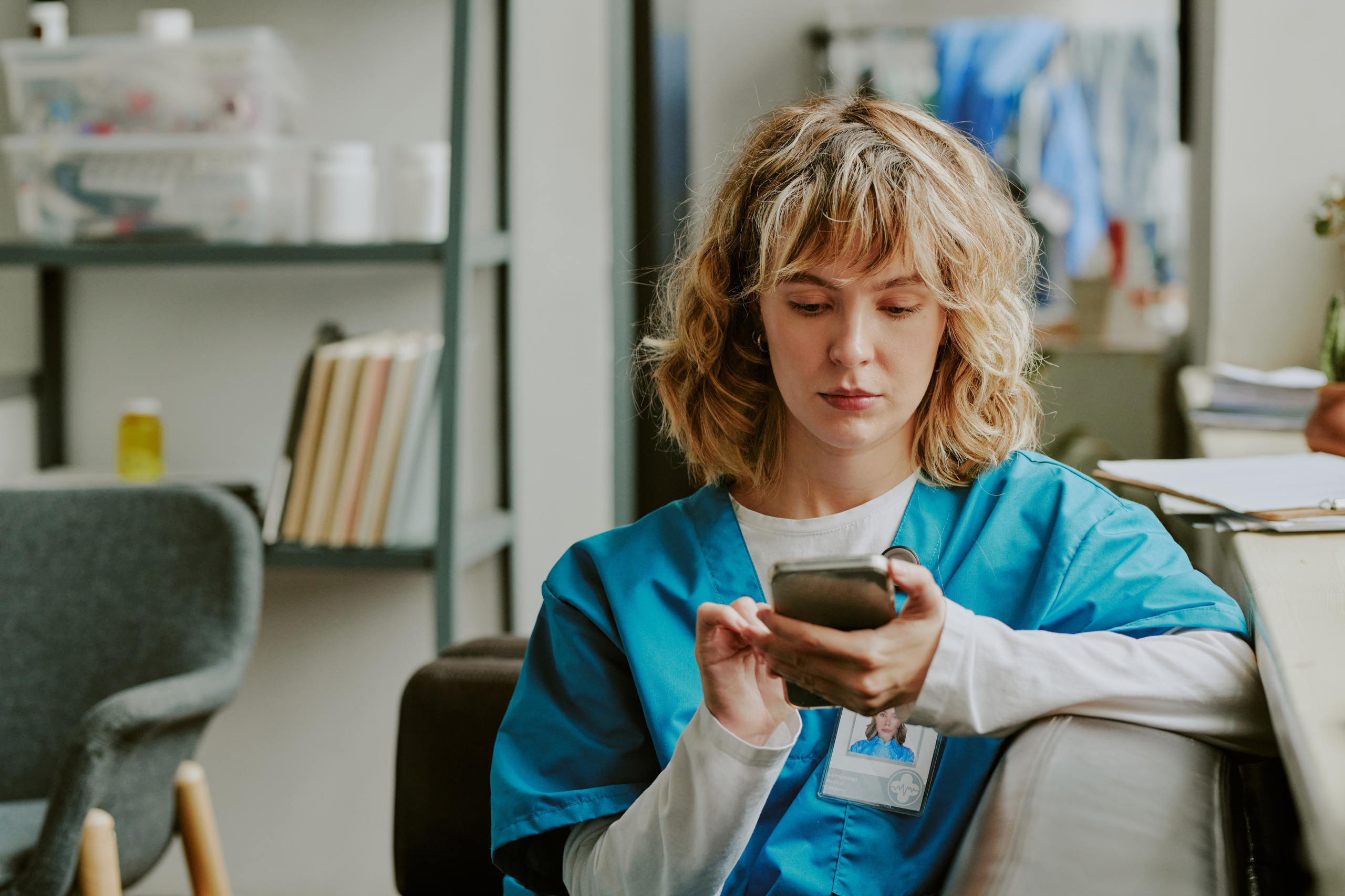 Nurse in scrubs submitting timesheet through the WorkTracker mobile phone timesheet app: The YouRecruit healthcare software